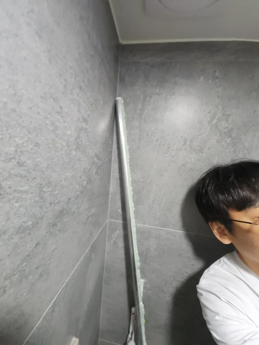 유리 철거 — 떼어 낸 금속 틀을 벽에 기대 둔 모습